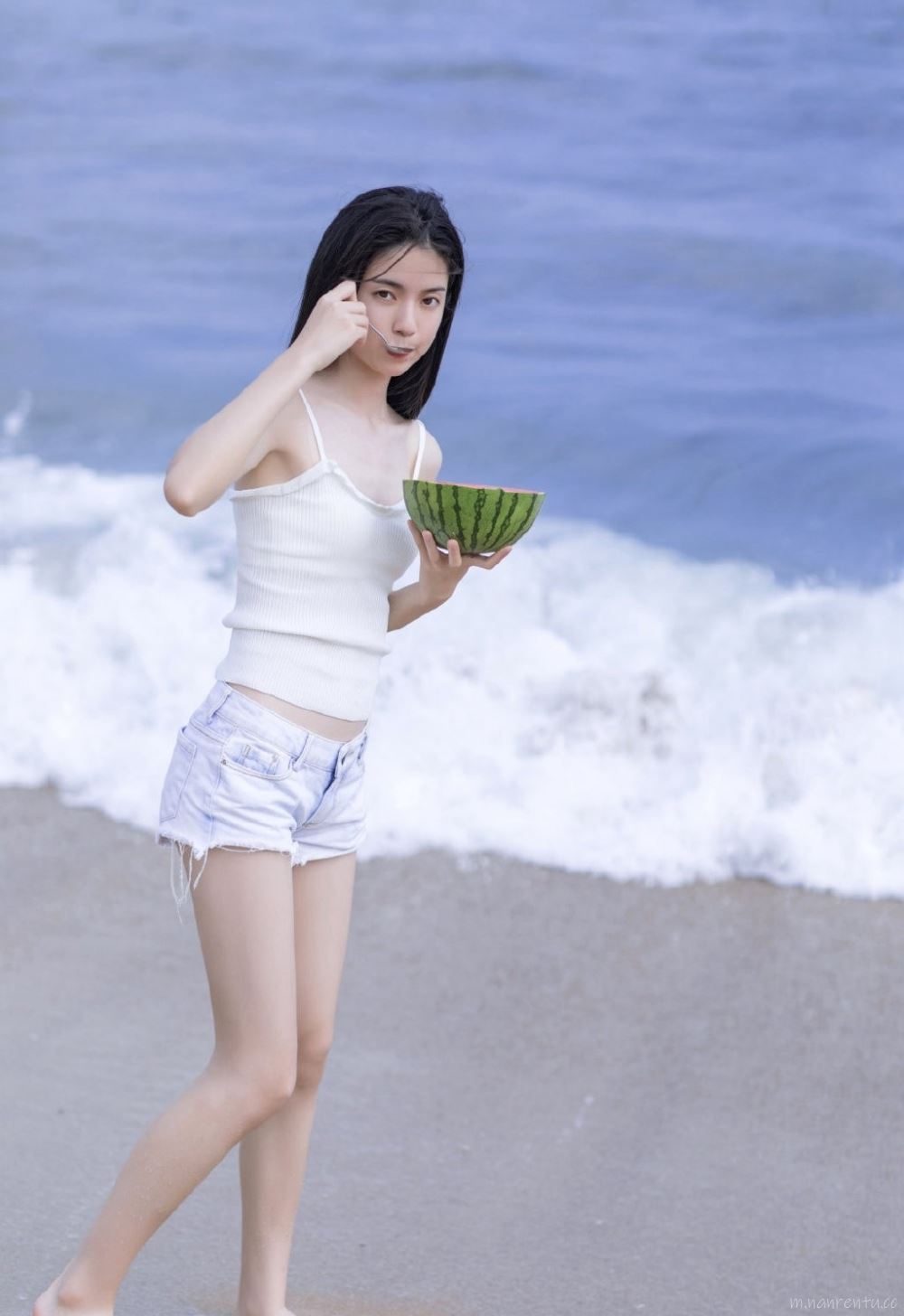 海边吃瓜玩耍的个性美女吊带热裤秀大长腿写真图片第9张
